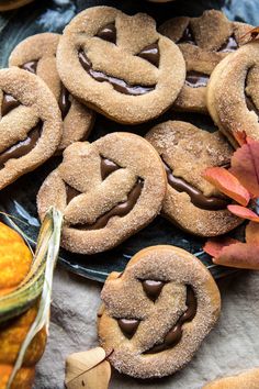 some cookies are on a plate with leaves and pumpkins in the backgroud