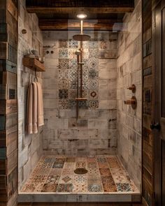 a walk in shower sitting next to a wooden floor and wall with tile on the walls