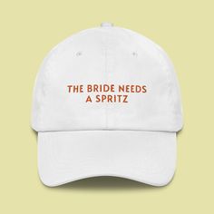 The Bride Needs a Spritz Cap, a stylish and fun accessory perfect for any bridal celebration. This cap, crafted from high-quality materials, offers comfort, a classic look, and a playful message that adds a touch of humor to any outfit. 🧢 Classic Style with a Fun Twist Embrace the charm of a classic dad cap with a modern, humorous design. The unstructured, low-profile fit provides a relaxed yet stylish look that's ideal for any casual occasion, especially bridal events. ✨ Playful Embroidery Fea White Curved Brim Baseball Cap For Wedding, Embroidered Wedding Hat, Outfit Classic, Bridal Events, Bachelorette Decorations, Embroidered Cap, Bridal Event, Dad Cap, Embroidered Caps