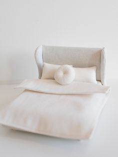 a white bed with two pillows on top of it