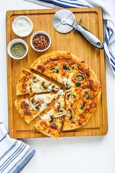 a sliced pizza on a cutting board with toppings