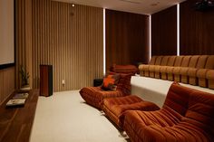 a living room filled with lots of brown couches next to a white carpeted floor