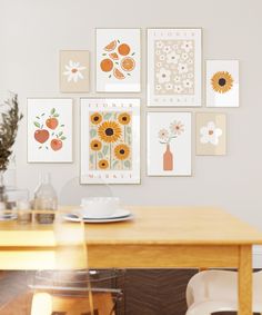 a wooden table topped with plates and bowls next to pictures on the wall above it