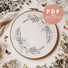 an embroidery pattern with flowers and butterflies around it