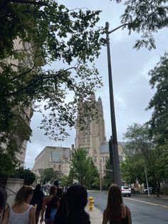 people walking down the street in front of a tall building