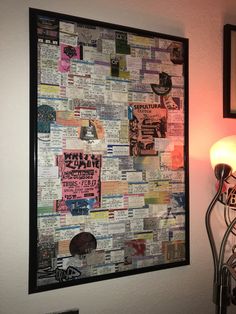 a wall hanging on the side of a white wall covered in newspaper and stickers