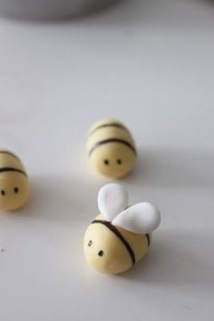 three small wooden bees sitting on top of a table