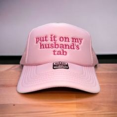 "Put it on my husband's tab" on your favorite color Otto Foam High-Profile Trucker Hat. How to Order: 1. Choose the color hat  2. Pick the color of thread   The saying can be customized. Message us before ordering with your request or any questions. Hat Description:  The Traditional Look 5-panel cap Seamless Foam Front Panel with Lining Matching Color Braid Visor Matching Fabric Undervisor, Adjustable Snapback SHAPE: High-Profile FABRIC:  100% Polyester Front,  Mesh Back VISOR: Pre-curved FIT & Customizable Pink Snapback Hat With Curved Brim, Wedding Snapback Trucker Hat, Custom Adjustable Wedding Hats, Adjustable Trucker Hat For Wedding, Personalized Adjustable Hats For Wedding, Personalized White Wedding Hat, Customizable Funny Adjustable Hat, Adjustable Funny Customizable Hats, Funny Adjustable Customizable Hats