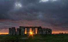 the sun is setting over stonehenge in england