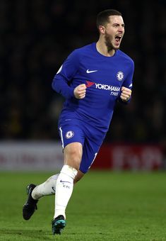 a man running on a soccer field with his mouth open and one foot in the air