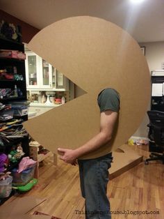 a man is holding up a cardboard letter