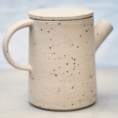 a white coffee mug with black speckles on it