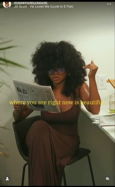 a woman sitting at a desk reading a newspaper