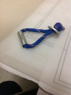 a blue and red rope on top of a white table next to a pair of scissors