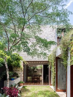 an outdoor dining area is surrounded by greenery and brick walls, along with a small patio