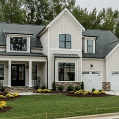 a large white house with lots of windows and landscaping in front of the door is shown