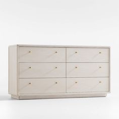 a white dresser with gold knobs on the top and bottom drawers, against a white background