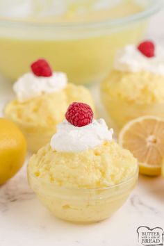 lemon cupcakes with whipped cream and raspberries on top, surrounded by lemon slices