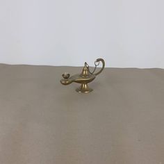 a small brass hook with a cat on it's head and tail sitting on top of a table