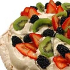 there is a pie with fruit on it and whipped cream in the middle, topped with kiwis