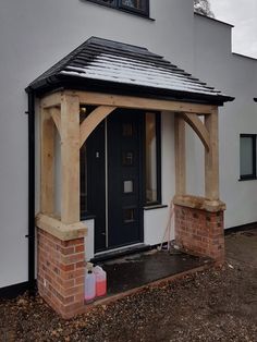 a small house with a black door and brick pillars