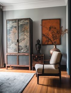 a living room filled with furniture and paintings on the wall next to a wooden floor