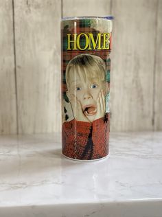 a can with a photo of a child on it sitting on top of a counter