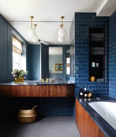 a large bathroom with blue brick walls and wood accents, along with a white bathtub