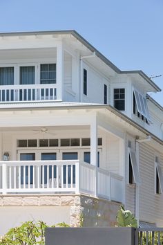 a large white house with two balconies on the second floor