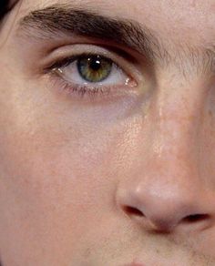 a close up of a man's face with brown eyes