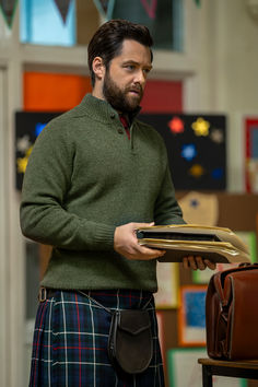 a man in a kilt holding a briefcase