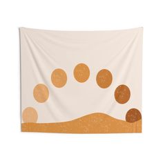 an orange and white wall hanging tapestry with circles on the ground in front of it