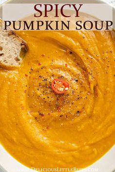 a white bowl filled with pumpkin soup and bread