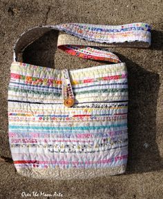 a multicolored purse sitting on the ground