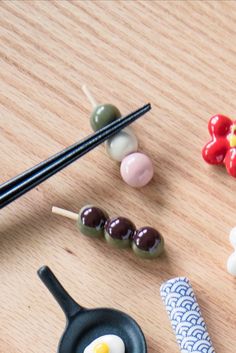 some food is laying out on a table with chopsticks and an egg in a frying pan