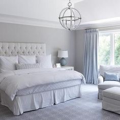 a white bed sitting in a bedroom next to a window