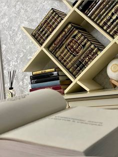 an open book is sitting on a desk next to books