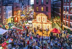 an aerial view of a crowded city street at night with christmas lights and decorations on the buildings