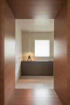 an empty room with wooden walls and flooring in front of a window that has blinds on the windowsill