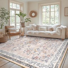 a living room filled with furniture and a large rug on top of a wooden floor