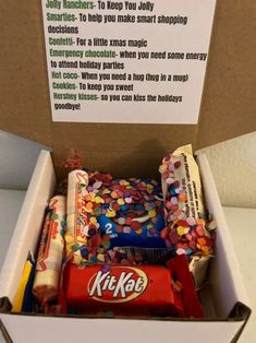 a box filled with lots of candy next to a sign that reads, kitkat