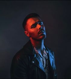 a man in a black leather jacket is looking at the camera with an intense look on his face