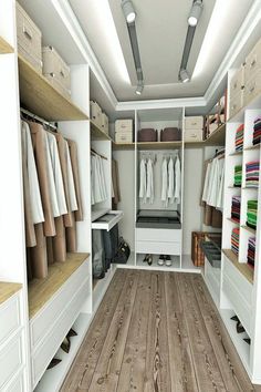 an organized walk - in closet with white drawers and wooden floors