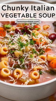 a white bowl filled with pasta and veggie soup on top of a table