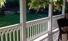 an outdoor dining table and chairs on a porch with white railings in the foreground