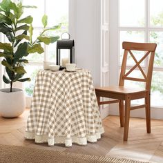 a table with a checkered cloth on it next to a chair and potted plant