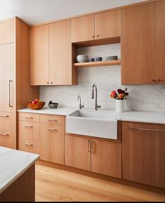 a kitchen with wooden cabinets and white counter tops, an island sink and dishwasher