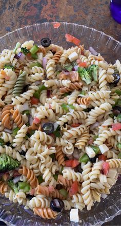 a pasta salad in a clear bowl on a table