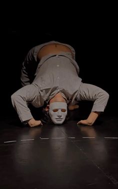 a man is upside down on the floor with his head up and hands behind him