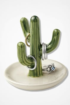 a green cactus ring holder on a white plate